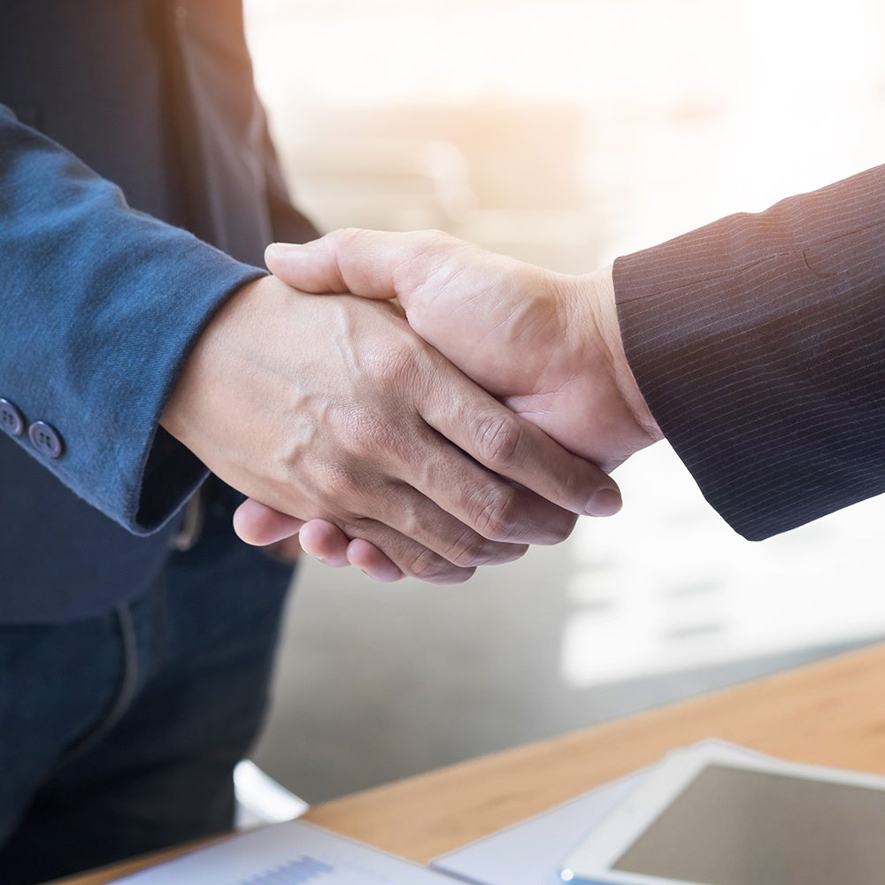 Two confident business man shaking hands during a meeting in the